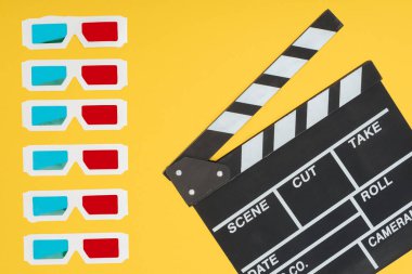 3d glasses in vertical row and clapperboard isolated on yellow clipart