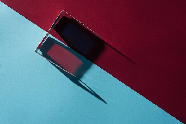 вид сверху на 3D очки с длинной тенью на синем и бордо фоне
