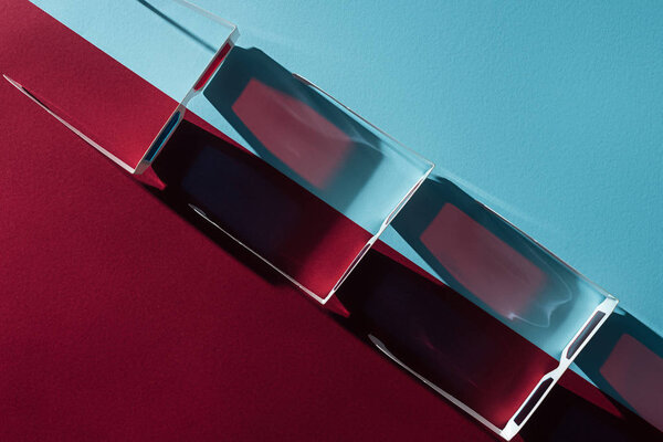 вид сверху на 3d очки подряд с длинными тенями на синем и бордо фоне
