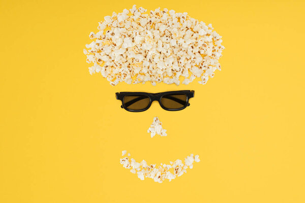 stereoscopic 3d glasses and fresh popcorn isolated on yellow