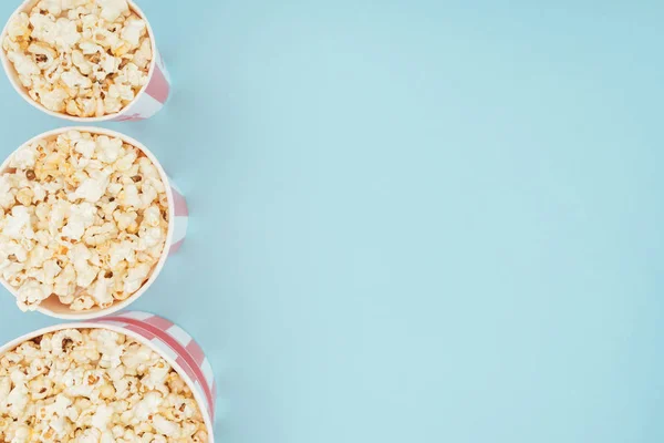 Bovenaanzicht Van Emmers Met Popcorn Verticale Rij Geïsoleerd Blauw — Stockfoto