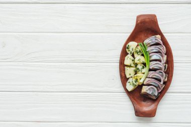 lezzetli patates ve soğan kopya alanı beyaz ahşap zemin üzerine toprak plaka ile ringa balığı Marine