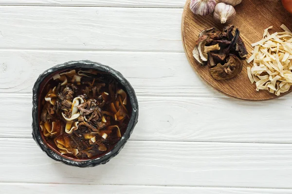 Bovenaanzicht Van Traditionele Champignonsoep Met Ingrediënten Het Bord Wit Houten — Stockfoto