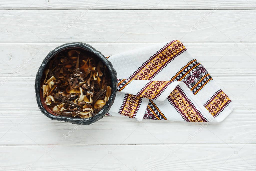 delicious traditional mushroom soup with embroidered towel on white wooden background with copy space