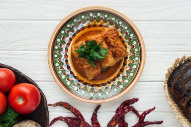 üstten görünüm geleneksel lahana dolması, maydanoz ile beyaz ahşap arka plan üzerinde rulo.