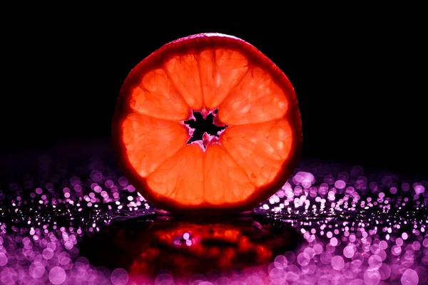 Schijfje Grapefruit Zwarte Achtergrond Met Rode Backlit Bokeh — Stockfoto