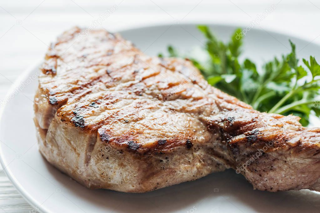 close up of delicious rib eye meat steak on plate with parsley 