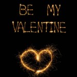 Close up view of be my valentine light lettering and heart on black background, st valentines day concept