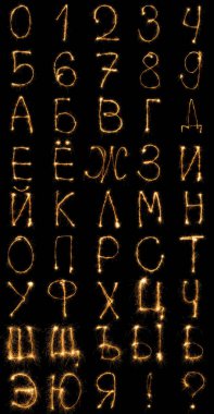 close up view of light russian alphabet and numbers on black background clipart