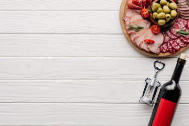 düz lay şişe kırmızı şarap, şişe açacağı ve et aperatifler Ahşap yüzeyi ile
