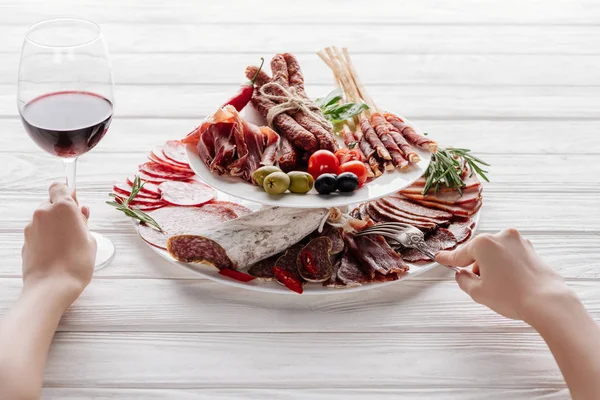 Colpo Ritagliato Donna Bicchiere Vino Rosso Spuntini Carne Superficie Legno — Foto stock gratuita