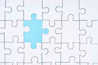düz lay mavi zemin üzerine beyaz puzzle parçaları ile
