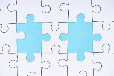 düz lay mavi zemin üzerine beyaz puzzle parçaları ile
