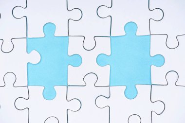 flat lay with white puzzle pieces on blue background clipart