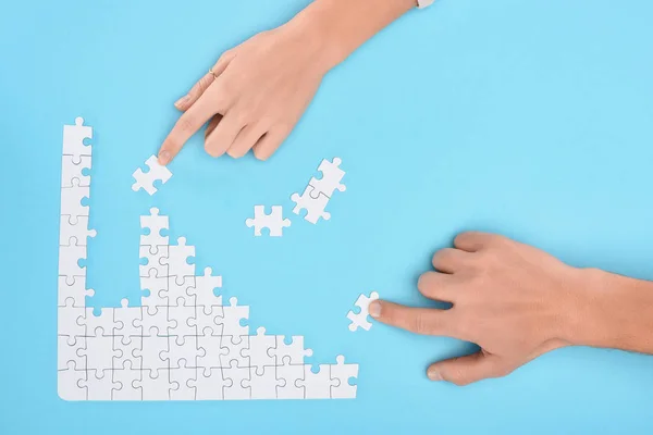 Erkek Kadın Mavi Zemin Işbirliği Kavramı Üzerinde Beyaz Puzzle Parçaları — Stok fotoğraf