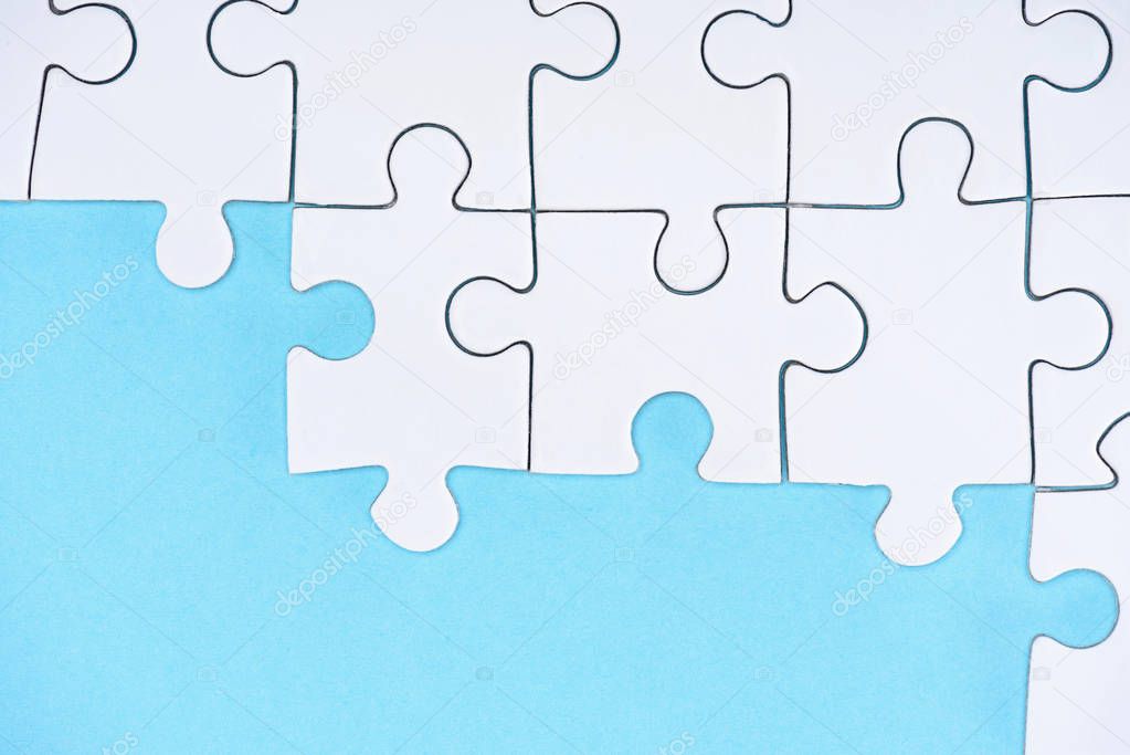top view of white puzzles arrangement on blue background