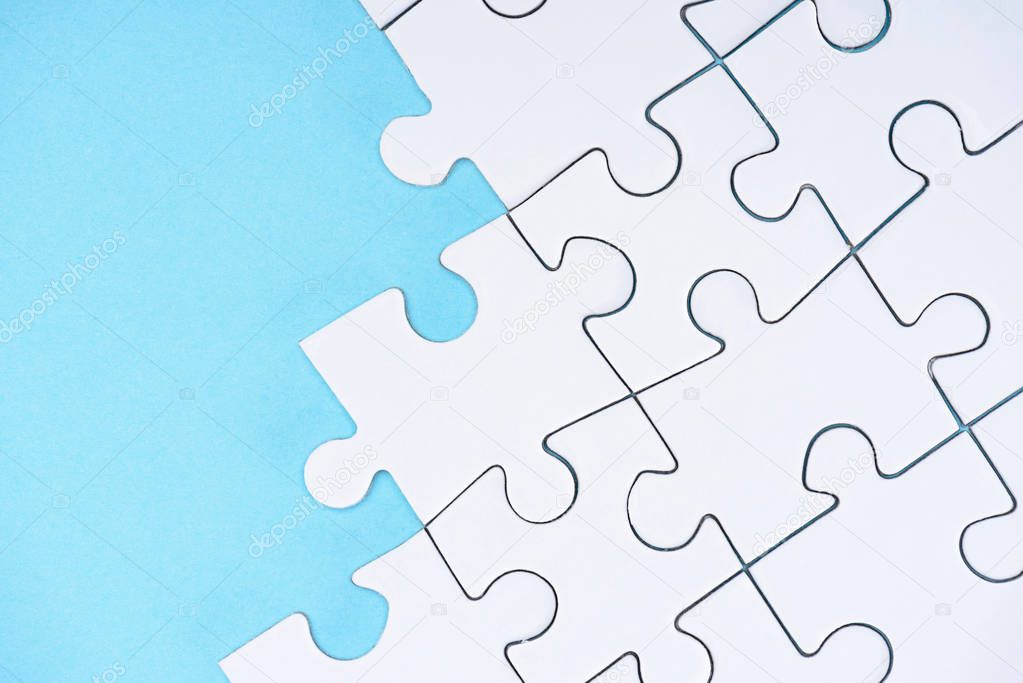 top view of white puzzles arrangement on blue background