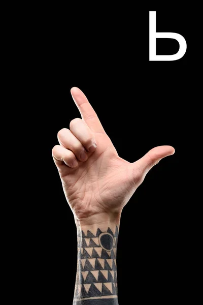 male tattooed hand showing cyrillic letter, sign language, isolated on black