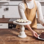 Visão parcial da mulher no avental cozinhar delicioso bolo de torta whoopie