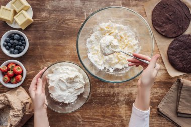cropped shot of woman preparing dough and cream for delicious cake  clipart