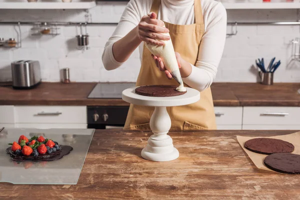 Частичный Вид Женщины Фартуке Украшающей Вкусный Домашний Торт Сливками — стоковое фото
