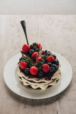 delicious whoopie pie cake with berries on white plate on marble table clipart