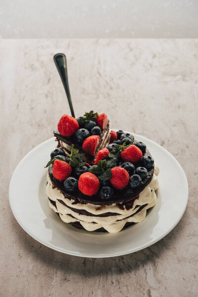 delicious whoopie pie cake with berries on white plate on marble table