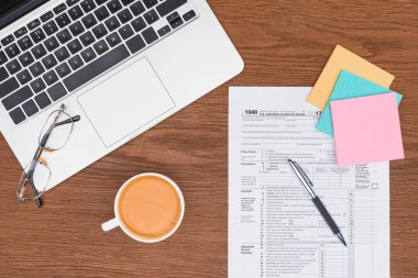 vergi formu, laptop, yapışkan notlar ve kahve işyerinde üstten görünüm
