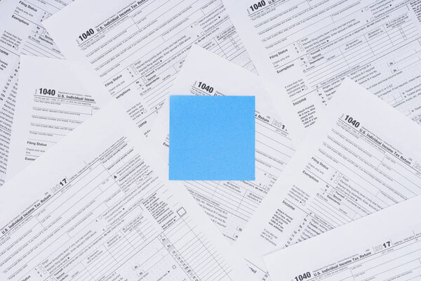 top view of empty blue card with tax forms on background 