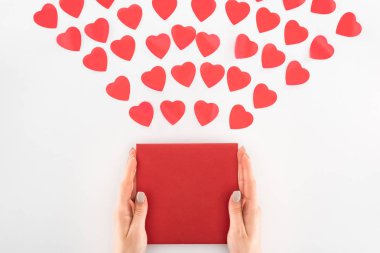 cropped shot of woman holding envelop under dozen red heart symbols isolated on white, st valentine day concept clipart