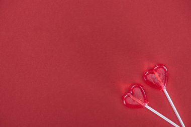 kırmızı arka plan, Sevgililer günü kavramı üzerinde iki kalp şeklinde lolipop üstten görünüm 