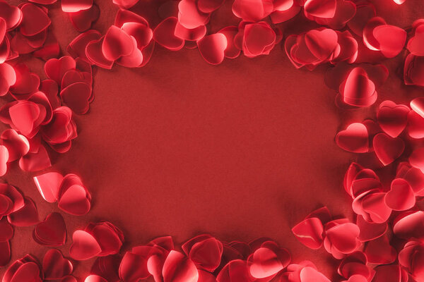 top view of decorative heart shaped petals on red background, valentines day concept 