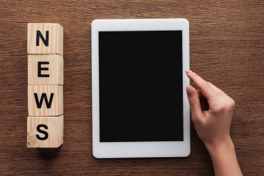 gazeteci tablet ile boş ekran, ahşap masa kelime haberleri ile tahta küpleri kullanarak kırpılmış görüntü