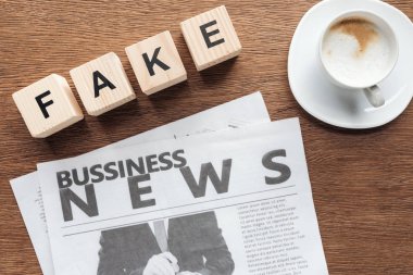 ahşap masa üzerinde word sahte, iş gazetesi ve kahve ile tahta küpler üstten görünüm