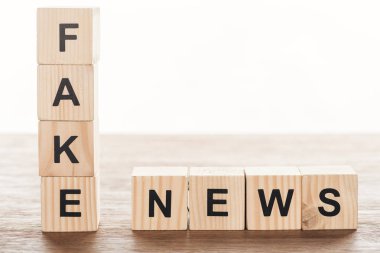 wooden cubes with words fake news on wooden tabletop clipart