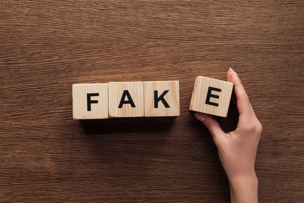 Imagen Recortada Periodista Tomando Cubos Madera Con Palabra Falsa Mesa — Foto de Stock