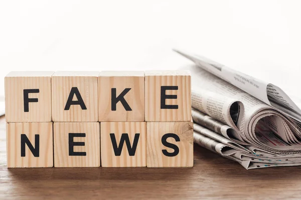 Holzwürfel Mit Wörtern Fake News Und Zeitungen Auf Holztischplatte — Stockfoto