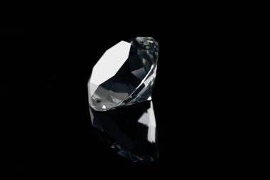 pure shiny diamond with reflection isolated on black clipart
