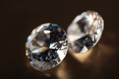 close up of big transparent diamonds on golden dark background  clipart