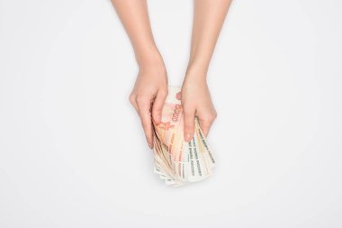 cropped view of woman holding Russian rubles in hands isolated on grey clipart