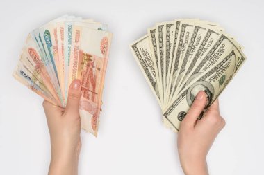 cropped view of woman holding russian rubles and dollars in hands isolated on grey clipart