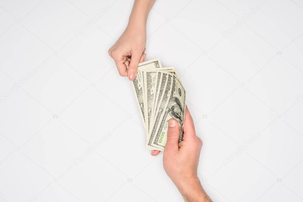 cropped view of couple sharing dollars isolated on grey