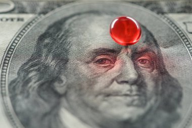 bir dolarlık banknot üzerinde parlak kırmızı yuvarlak ilaç yakın çekim