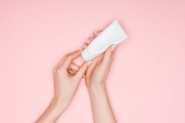 cropped view of female hands with hand cream isolated on pink clipart