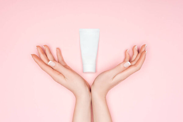 cropped view of female hands with hand cream isolated on pink