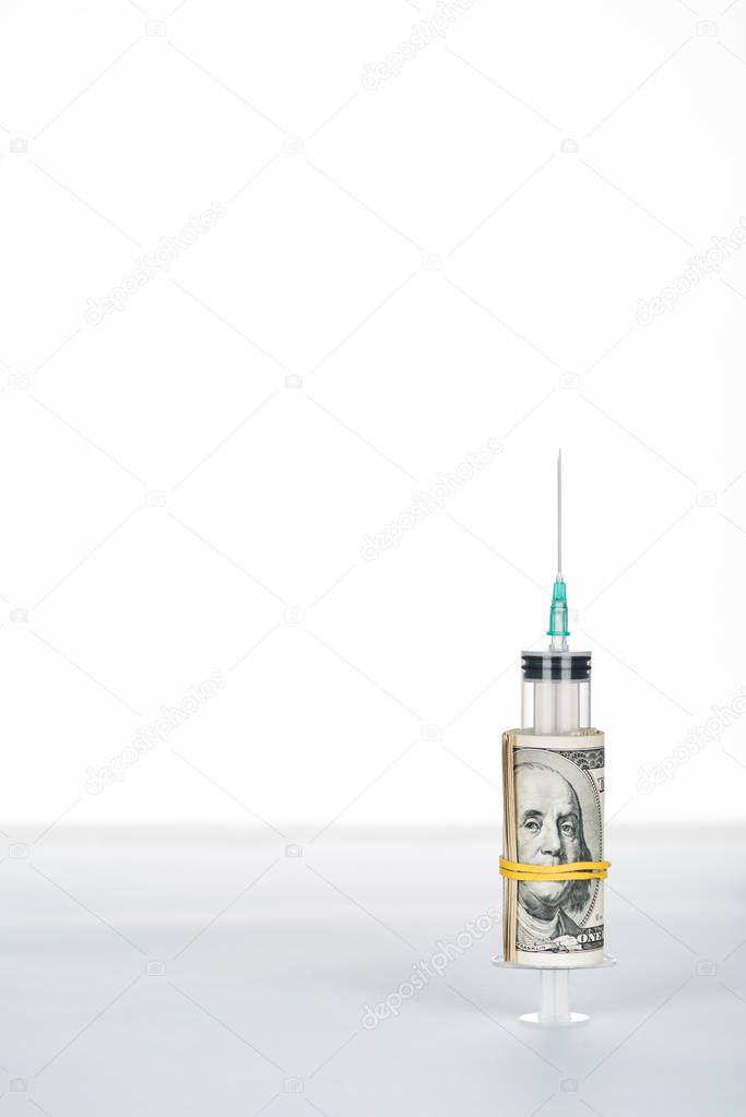 money roll and syringe on grey surface isolated on white