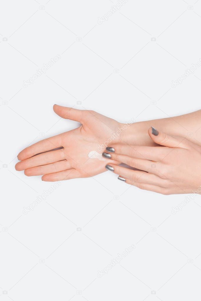 partial view of woman applying hand cream isolated on white