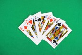 pohled shora zelené pokerového stolu s nepřeložené hrací karty, tři královny a dva kluci