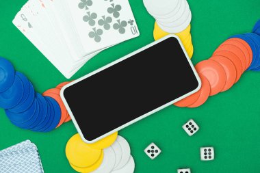 üstten görünüm çok renkli çip, dices, iskambil ve akıllı telefon ile yeşil poker tablo