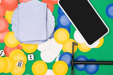 üstten görünüm çok renkli cips, oyun kağıtları, dices, sopa ve smartphone ile yeşil poker tablo